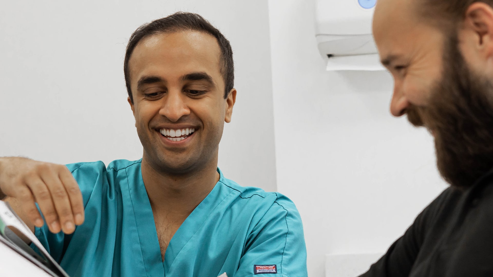 Dr Mohsin Patel explains a treatment to a patient.
